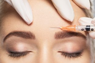Woman getting cosmetic injection of botox near eyes, closup. Woman in beauty salon. plastic surgery clinic.